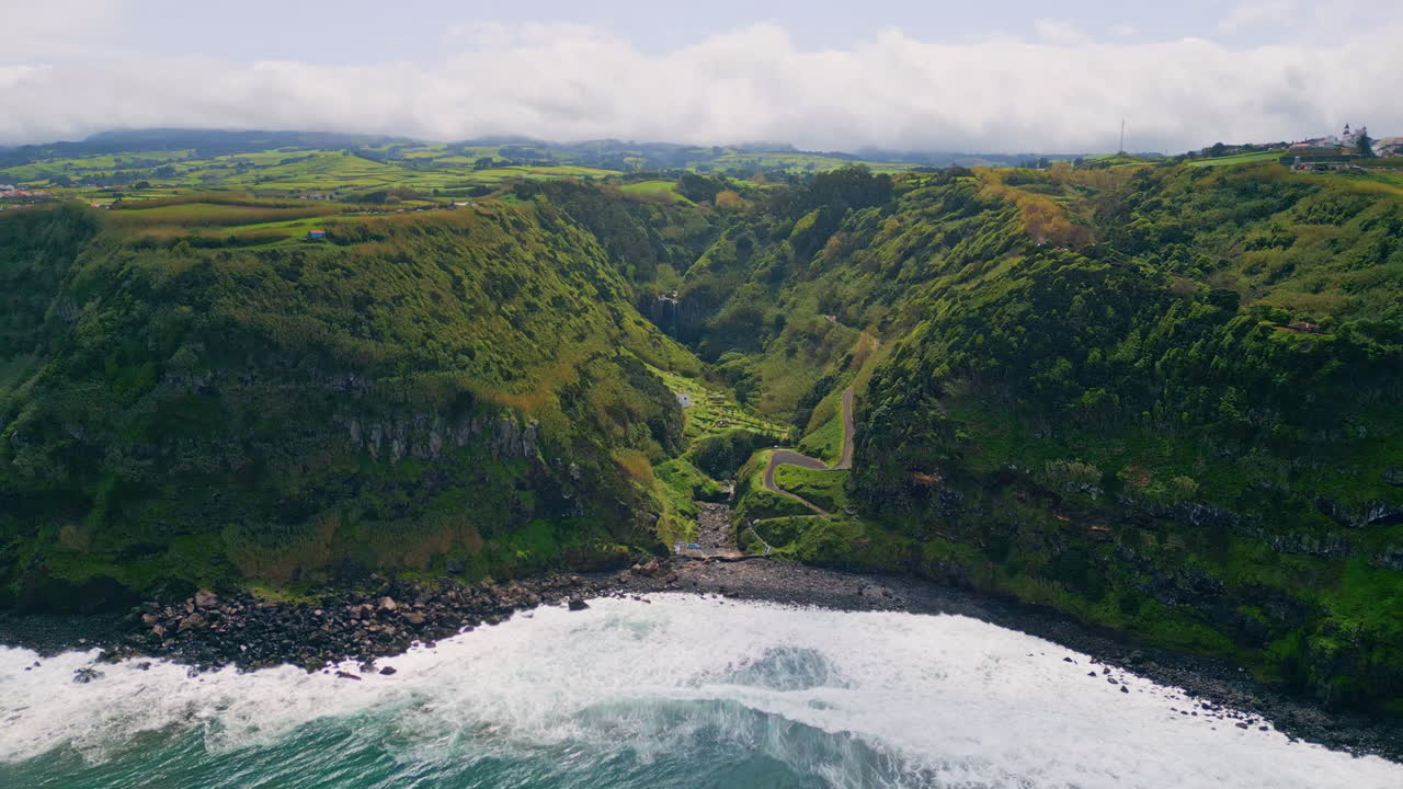verdes encostas costeiras acidentadas encontrando espuma do oceano vista aérea. ondas rolando