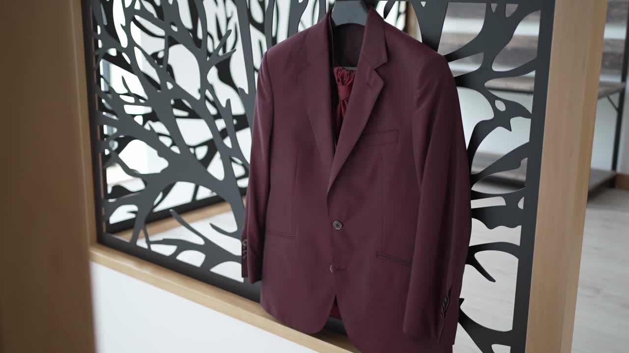 나무 프레임으로 세련된 검은색 절단 배경에 매달린 마룬 웨딩 슈트