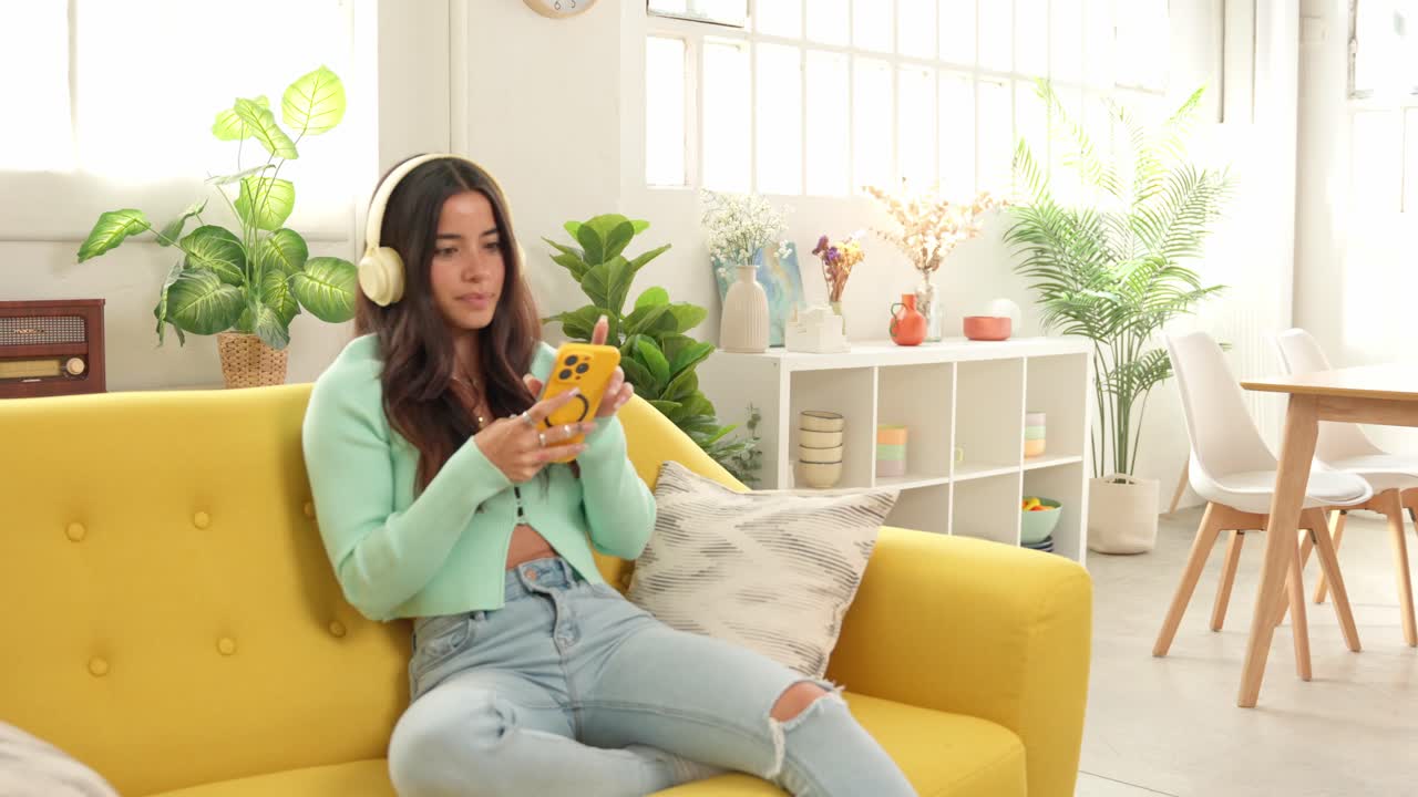 Woman listening to music on her phone at home