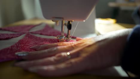 stitching the decorative and intricate quilt block pieces together on a sewing machine - isolated close up