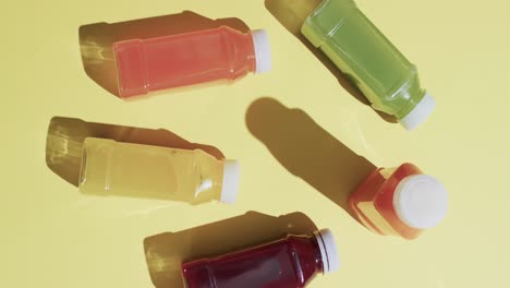 video de botellas con jugos de frutas con espacio de copia sobre fondo amarillo