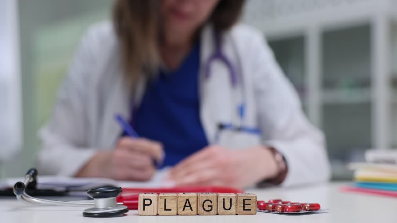 Plague Word Blocks on Doctor's Desk with Stethoscope and Pills