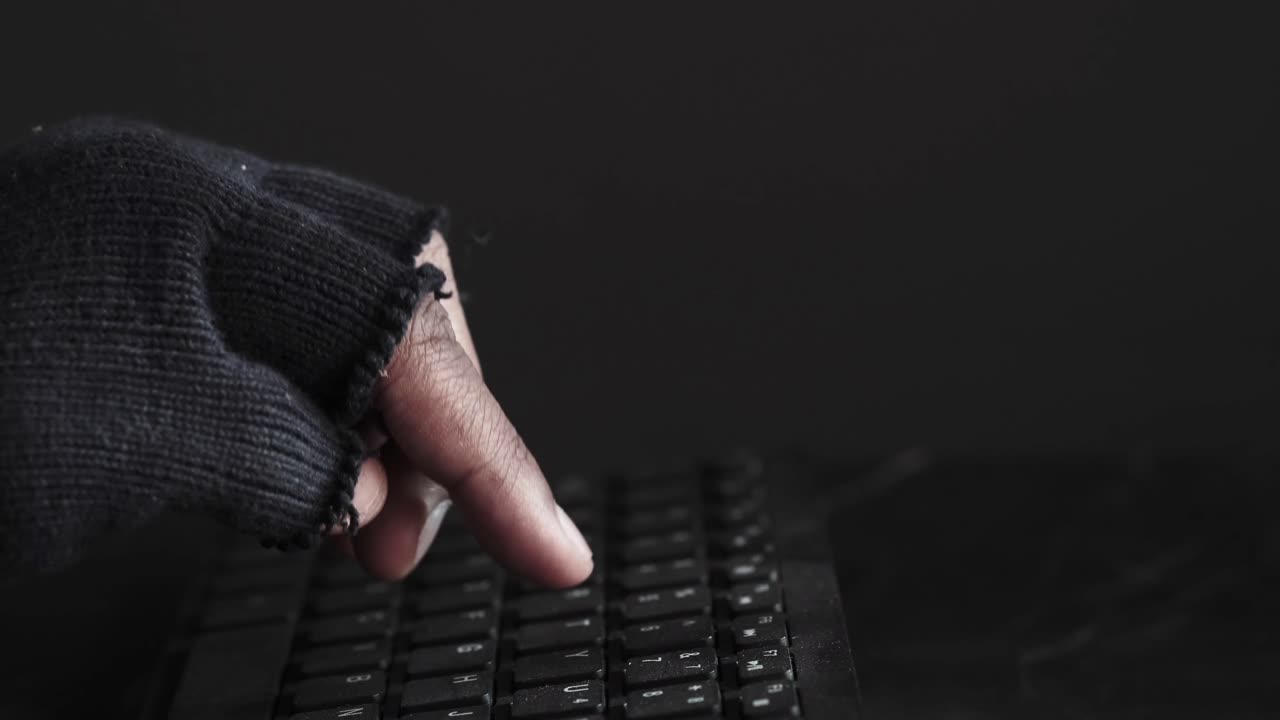 persona escribiendo en un teclado en un entorno oscuro