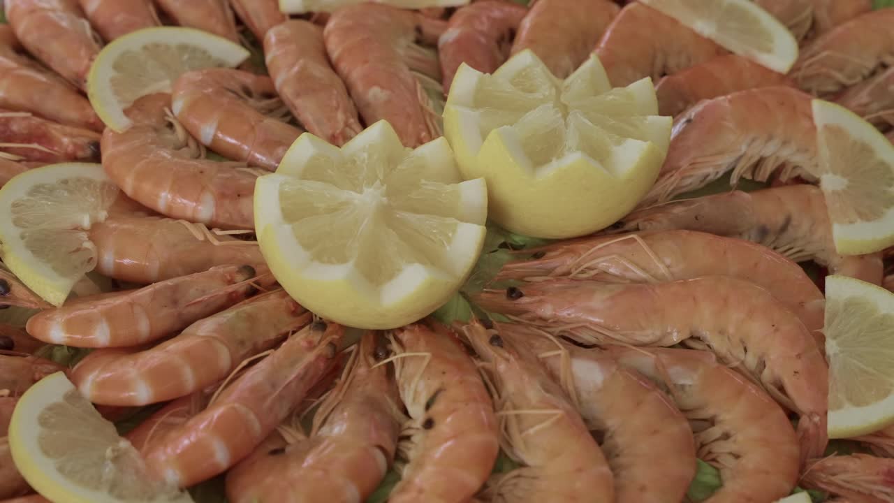 레몬 가니쉬와 함께 원형 패턴으로 배열된 조리된 새우의 상세 뷰