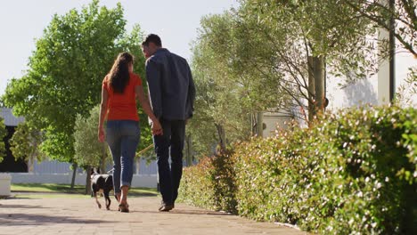 Happy-caucasian-couple-is-taking-their-dog-for-a-walk