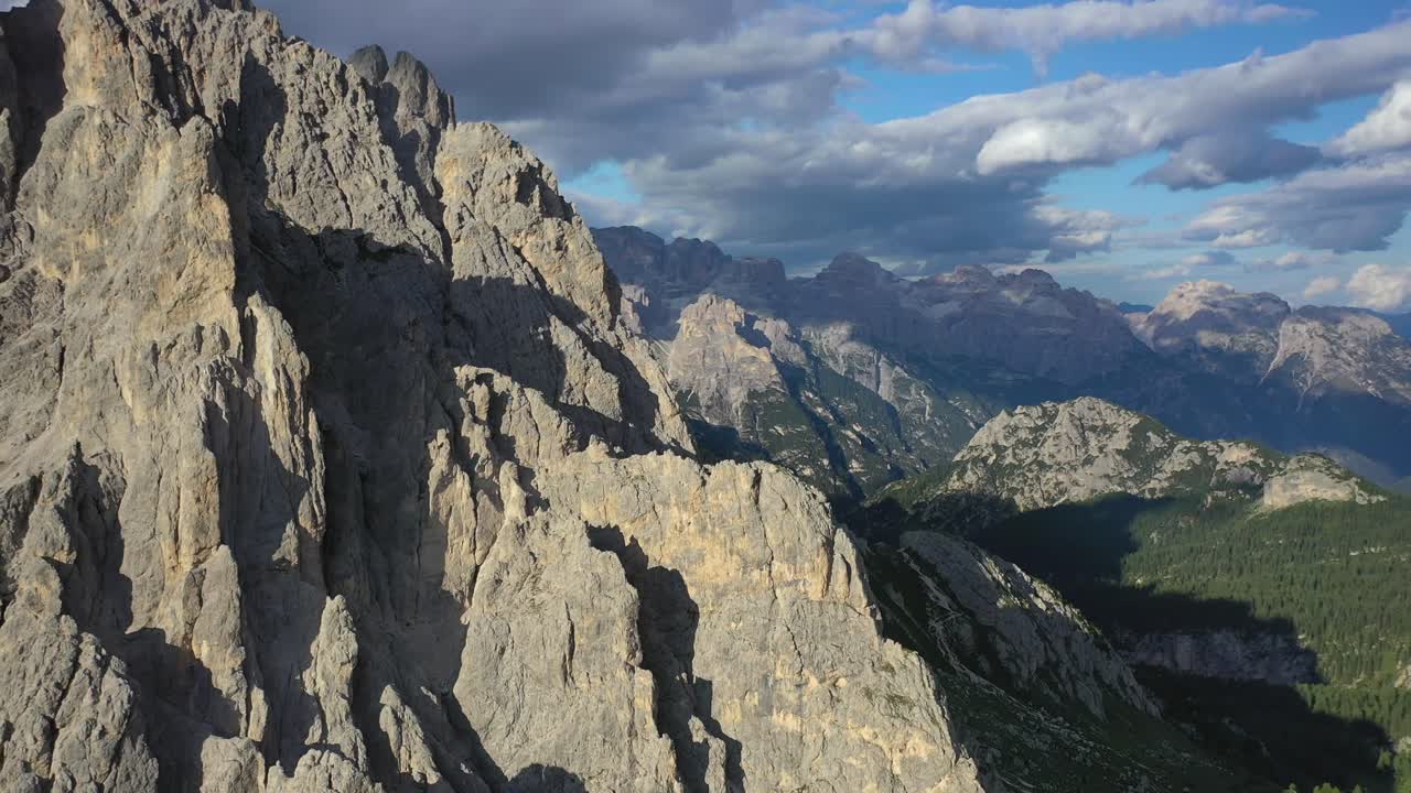 Mountain peaks of Cadini di Misurina in the Dolomites at sunset, forward aerial