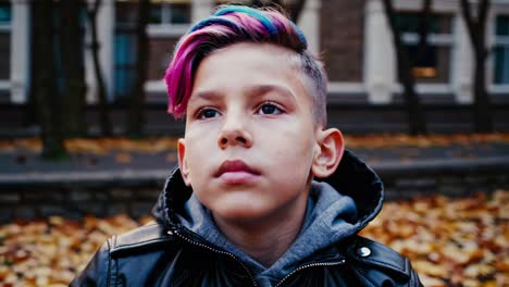 boy with colorful hair in autumn park