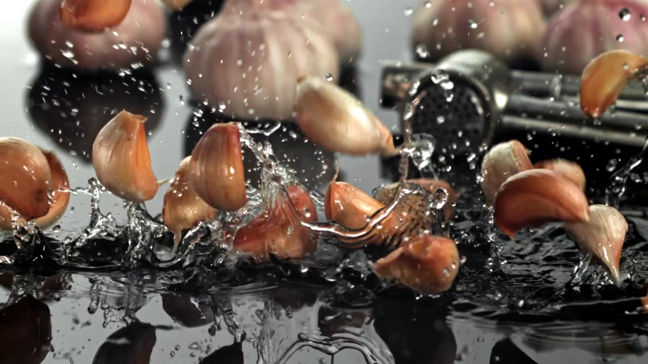 Garlic Cloves Falling and Splashing into Water in Super Slow Motion