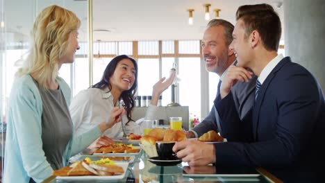 Women-and-businessmen-interacting-with-each-other-while-having-breakfast