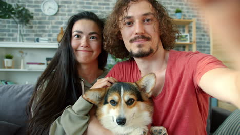 happy couple with dog taking a selfie