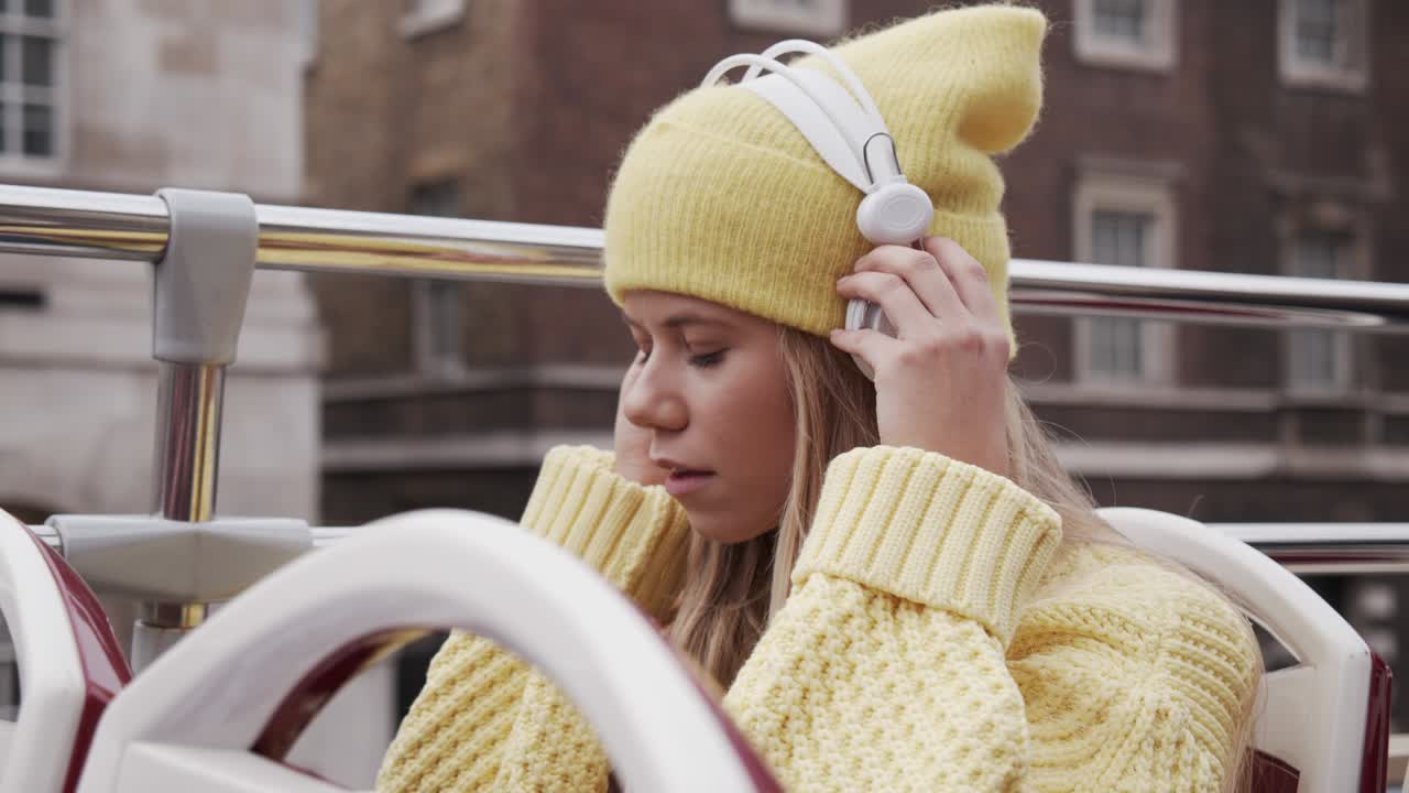 Teenage Girl Putting On Headphones On Bus