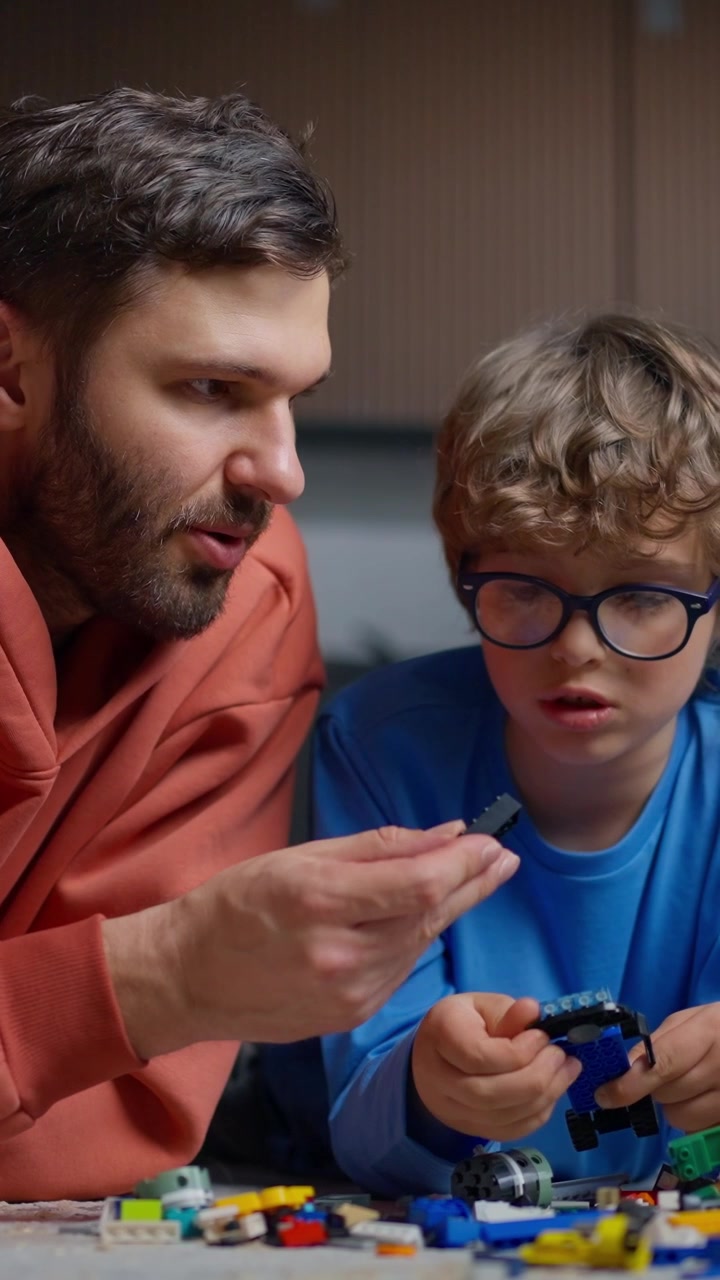 Padre e figlio che costruiscono un'auto giocattolo con blocchi colorati