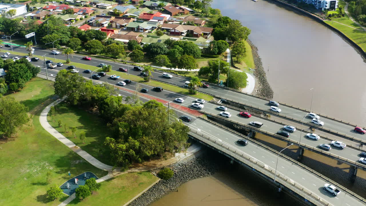 작은 마을의 강 위 다리에서 피크 시간 교통 혼잡을 내려다보는 공중 드론, 4k