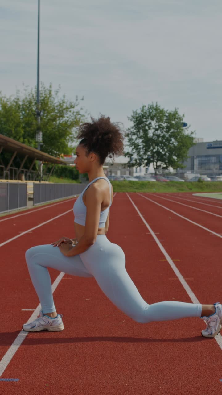 Donna che fa stretching su una pista