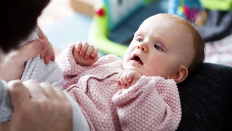 dad holding baby daughter legs