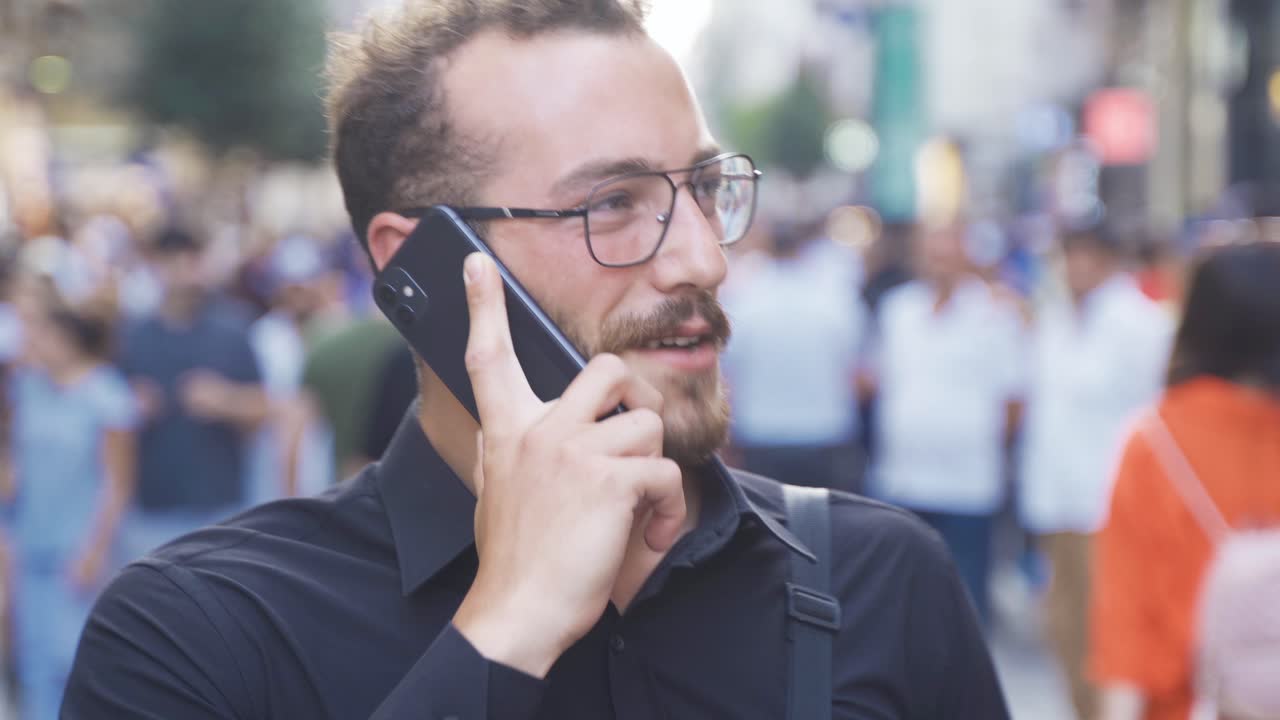 hombre feliz haciendo una llamada telefónica en la calle.