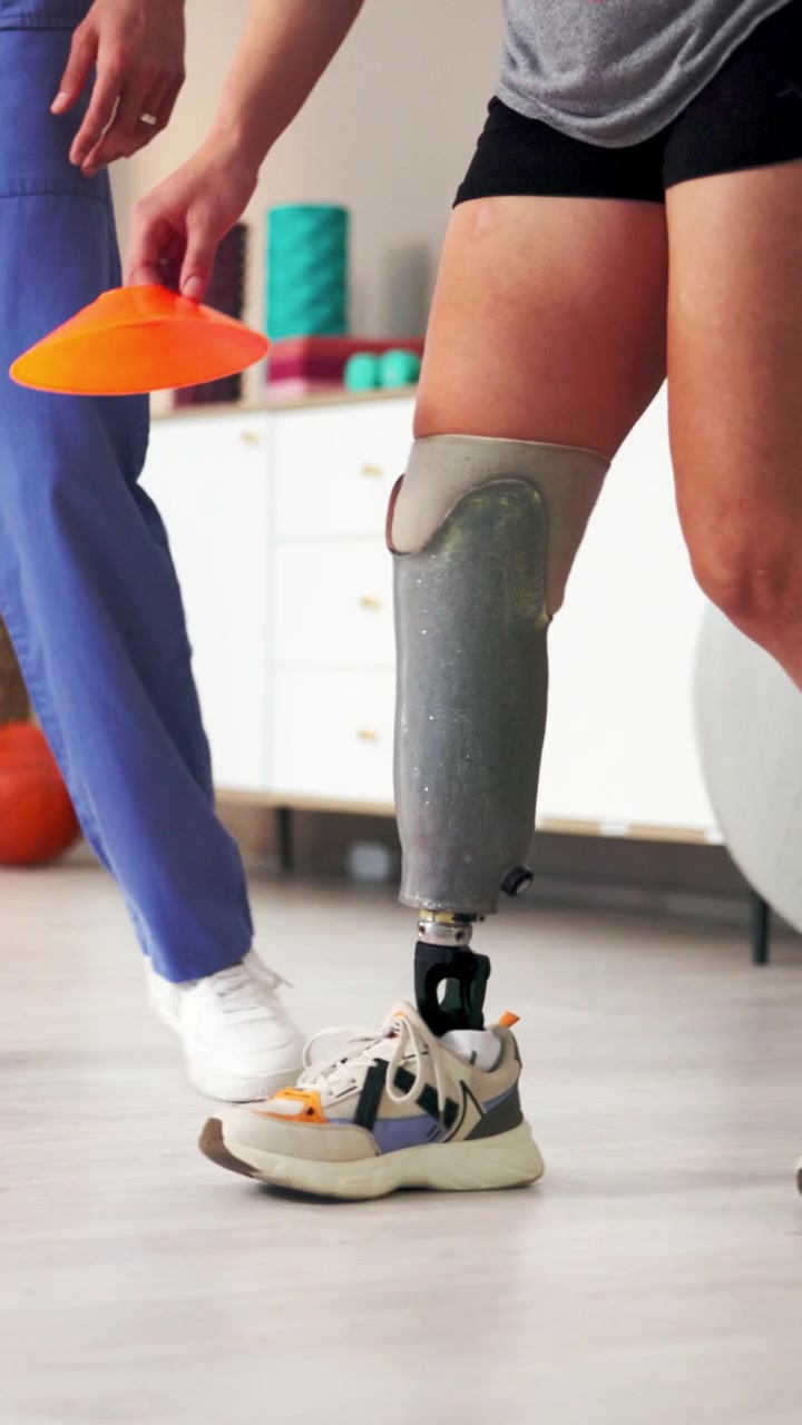 Physical Therapist Assisting Amputee Patient with Balance Exercises