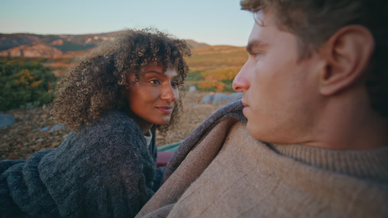 Enamoured woman looking boyfriend evening picnic on hills closeup. Tender pair