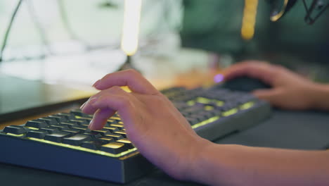 primer plano de una jugadora usando el teclado y el ratón de la computadora para una transmisión en vivo