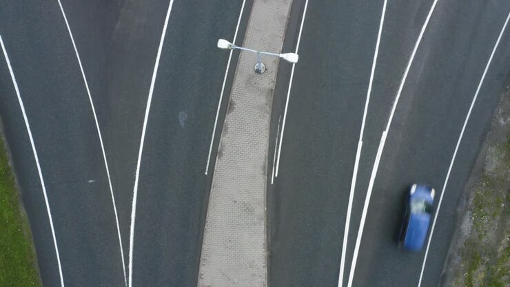 Top down aerial view in the middle of a motorway in Finland near Helsinki as cars quickly pass through the frame