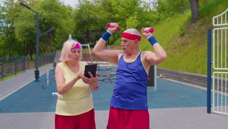 Senior-old-woman-grandmother-coach-teaching-grandfather-with-sport-weightlifting-cardio-exercises