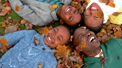 Animation-of-autumn-leaves-falling-over-happy-african-american-family-in-park