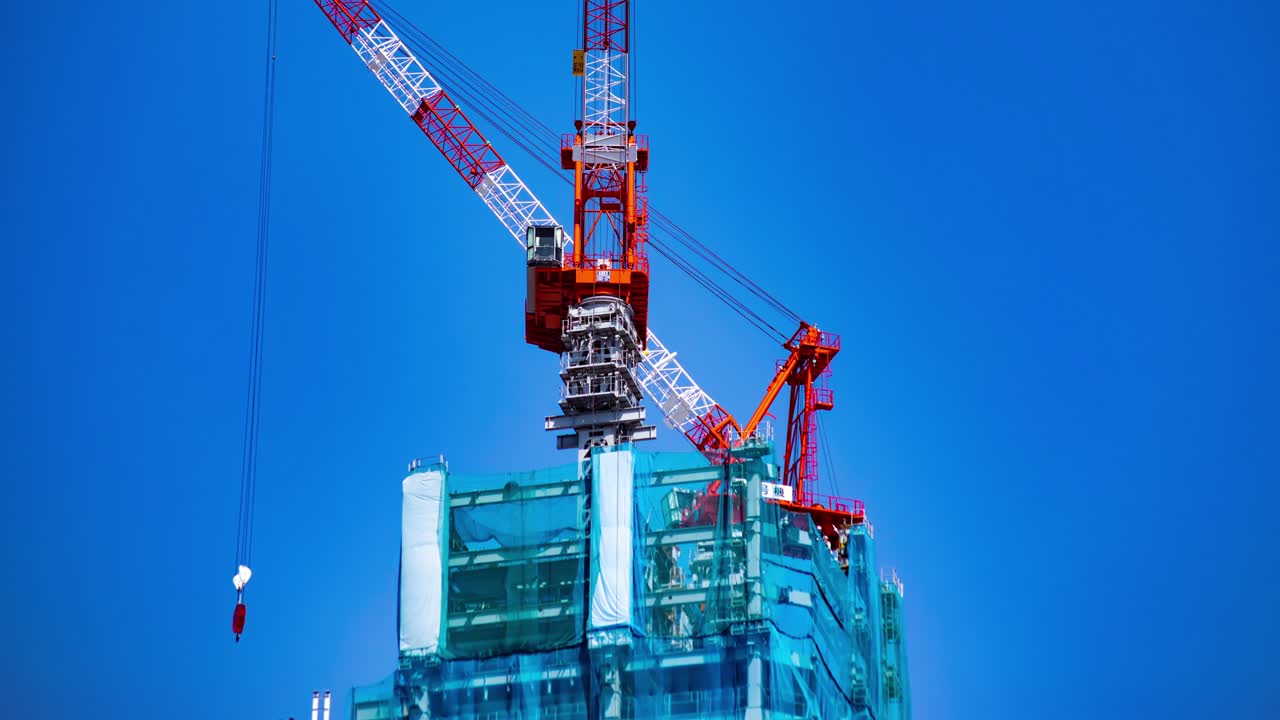 un lapso de tiempo de grúa de ida y vuelta detrás del cielo azul en la construcción en tokio panning