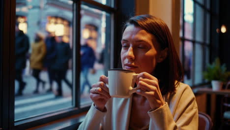 woman enjoying coffee in a cafe with city view