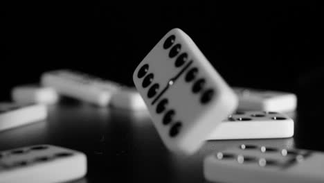 white domino dice fall on a black background