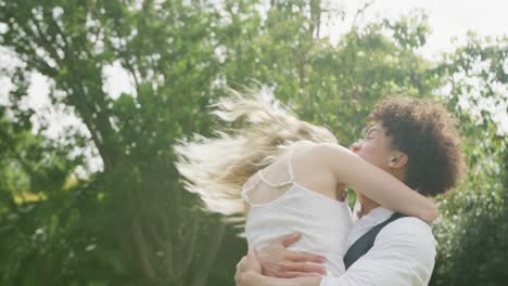 happy diverse couple in garden on sunny day at wedding