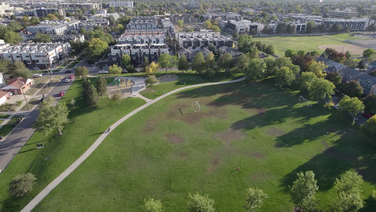 A 4K drone shot of a sunny day over Hallack Park, among a quiet and pristine neighborhood between Sloans Lake and Empower Field, in Denver, Colorado
