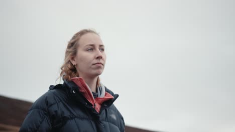 woman on a hill staring at the horizon on cloudy day