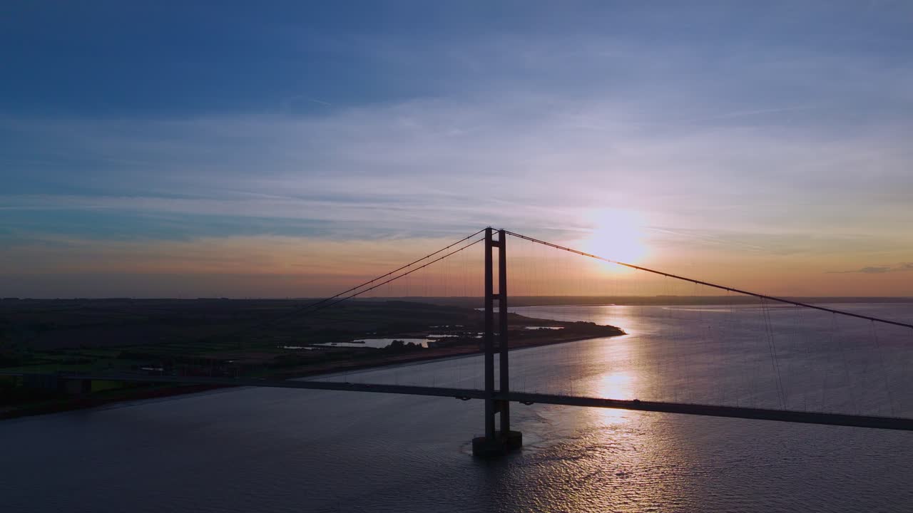 The Humber Bridge, a canvas for twilight's beauty, hosts a graceful procession of cars in this aerial drone masterpiece