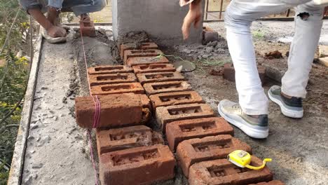 trabajadores de la construcción que construyen paredes de ladrillo - concepto de trabajo duro, trabajo manual