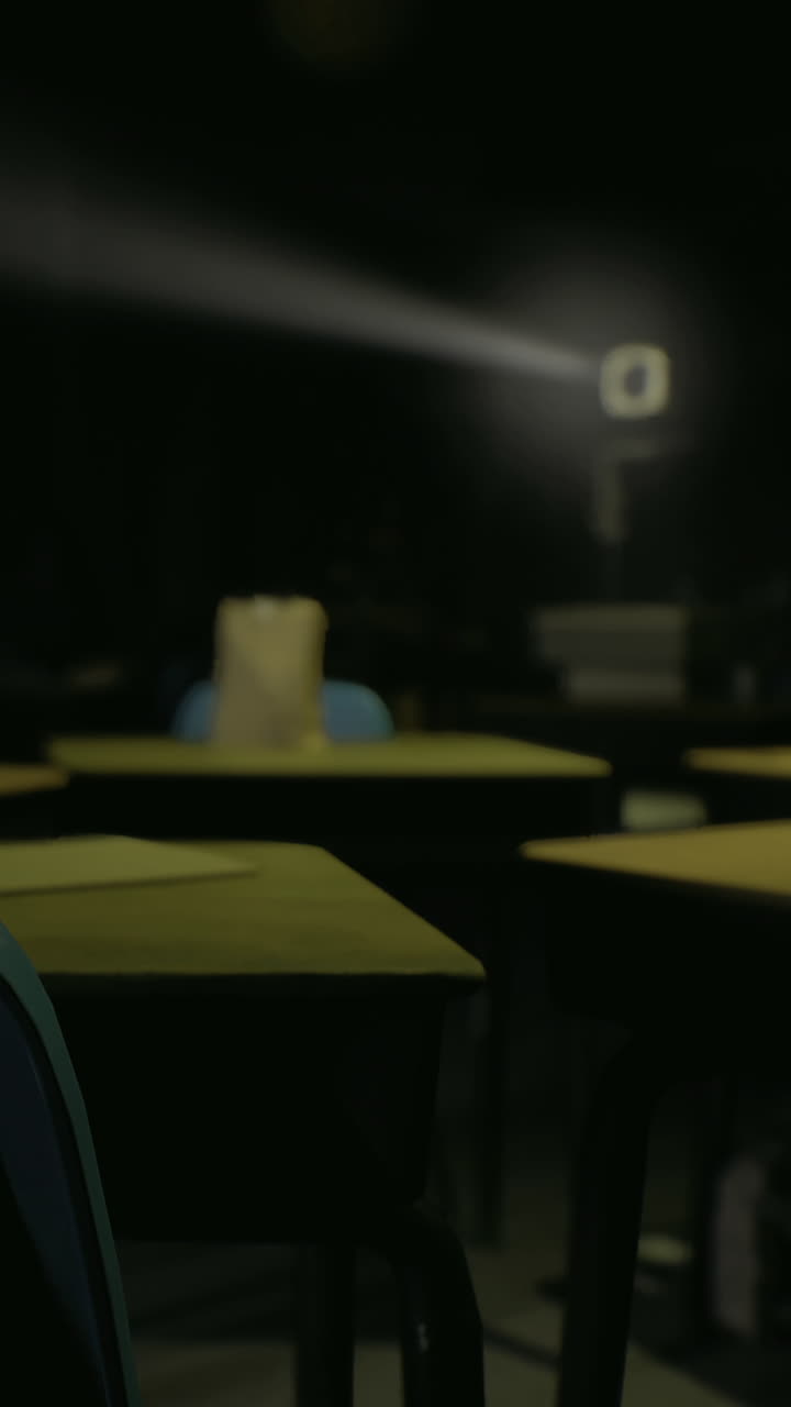 Aula scolastica con banchi vuoti e una fonte di luce concentrata di sera