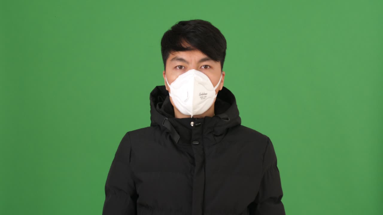 Man Wearing a Face Mask in Front of a Green Screen