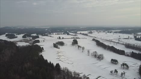 Toma-Aérea-De-Un-Campo-De-Golf-Durante-El-Invierno,-Fairway-Y-Bunkers-Cubiertos-De-Nieve