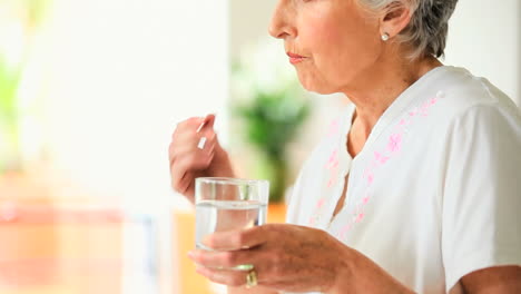 mujer anciana tomando una píldora