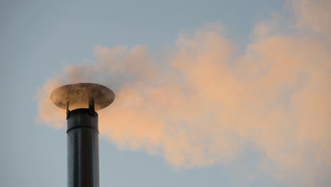 smoke from a wood stove coming out of a chimney on a cold morning