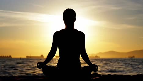 woman doing the lotus pose at sunset