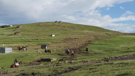 los granjeros de lesotho salen a caballo de una aldea africana de camino a casa