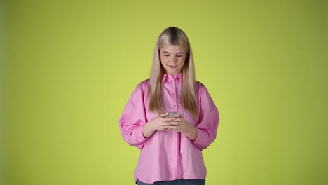 Young-woman-reads-shocking-news-on-smartphone,-face-frozen-look,-studio-shot