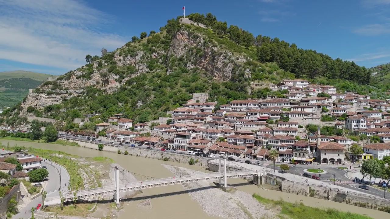 Città vecchia di Berat sulle rive del fiume Osum, vista drone grandangolare con castello sullo sfondo, giornata di sole