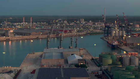 Aerial-view-of-the-industrial-and-port-area-of-Ravenna-,chemical-and-petrochemical-pole,thermoelectric,metallurgical-plants-and-hydrocarbon-refinery-and-liquefied-natural-gas-tanks-shot-at-night