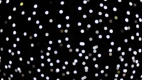 abstract white blurred lights sparkling and glowing on black background. christmas or new year holiday concept