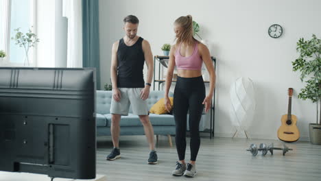 couple doing online fitness class at home