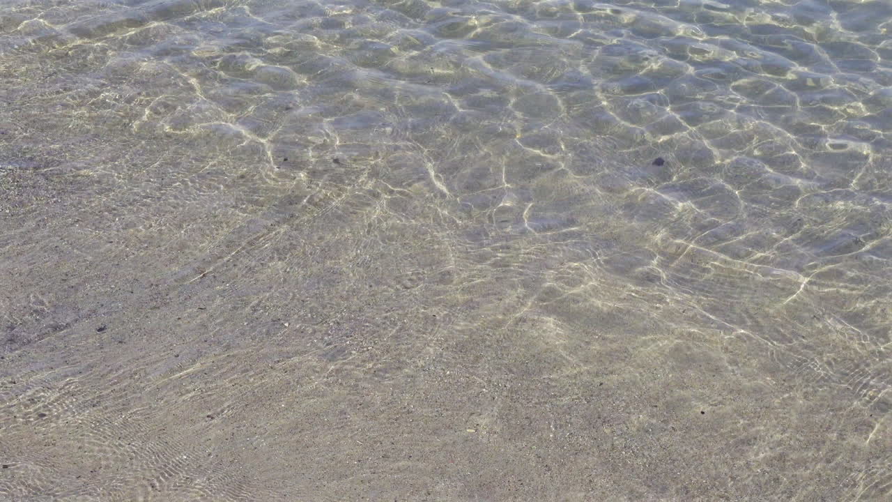 Close up of waves crashing on the beach in daylight
