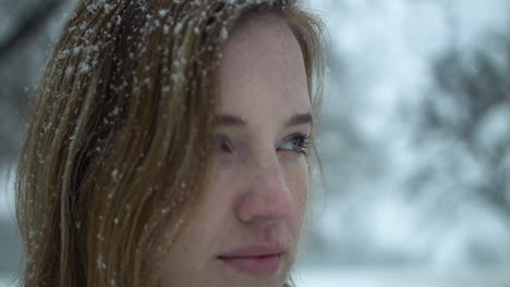 mujer feliz afuera en cámara lenta nieve de invierno como copos de nieve caen en cámara lenta cinematográfica