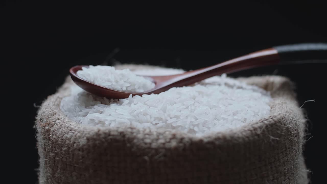 Seeds Rice In The Wooden Spoon On A Rustic Bag  Rotating In Slow Motion