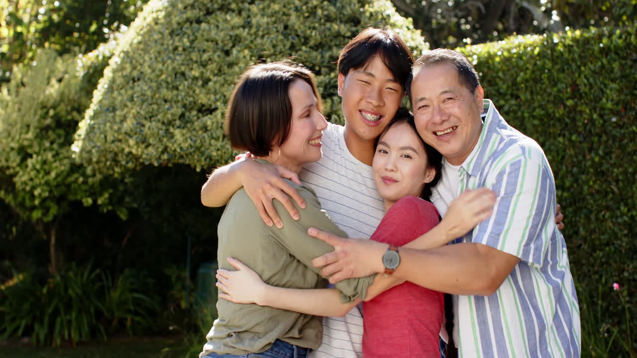 Smiling family hugging together outdoors, enjoying quality time and bonding